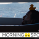 Keanu Reeves' Neo takes a relaxing bath in front of a large window with a rubber duck on his head in The Matrix: Resurrections.